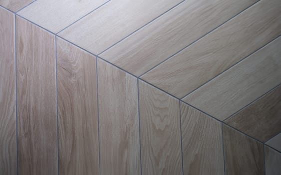 Oak texture of floor with tiles imitating parquet. Traditional herringbone pattern on wooden floor concept