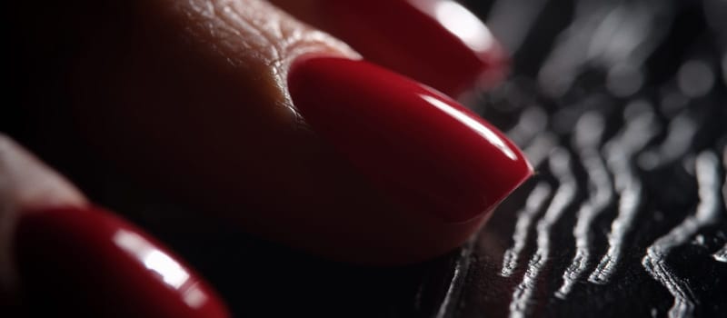 Stylish beautiful red nails on dark background. Classic graceful manicure concept