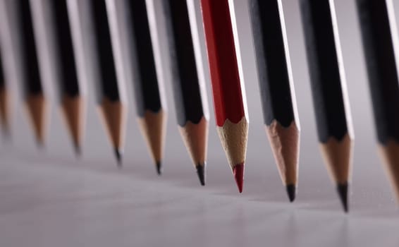 Black pencils in the center with red. Leadership uniqueness and business success concept