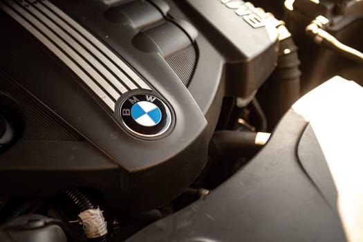 Milan, Italy 9 April 2024: Close-up of a BMW engine with the emblem clearly visible, showcasing automotive craftsmanship.