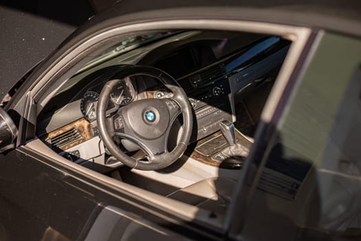 Milan, Italy 9 April 2024: Detailed view of a BMW car interior showcasing the steering wheel with the visible emblem.