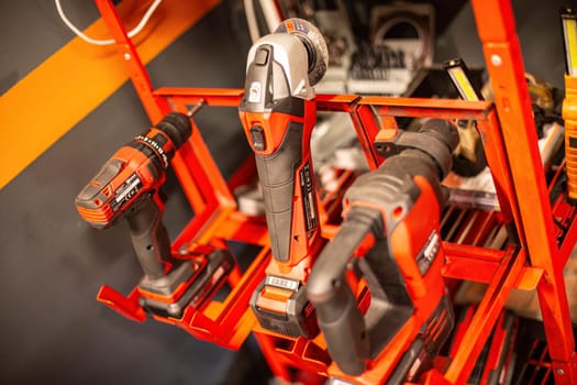 Milan, Italy 9 April 2024: Organized tools on shelf including drill, screwdriver, and wrench in workshop setting.