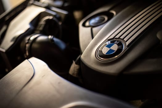 Milan, Italy 9 April 2024: Close-up of a BMW engine with the emblem clearly visible, showcasing automotive craftsmanship.