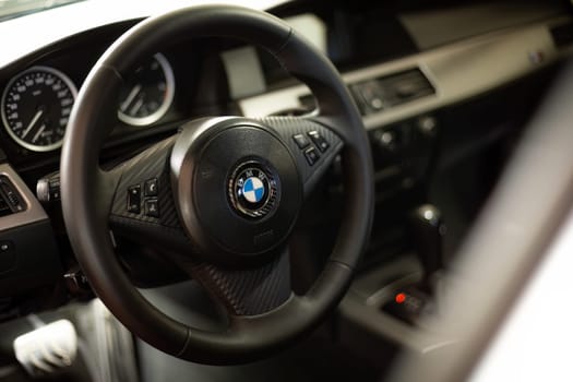 Milan, Italy 9 April 2024: Detailed view of a BMW car interior showcasing the steering wheel with the visible emblem.