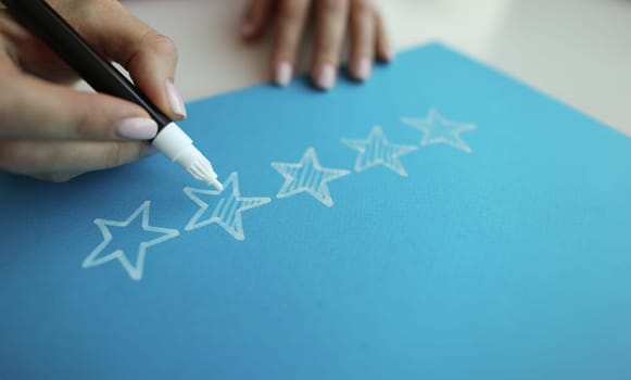 Person draws five stars in the recommendations with white felt-tip pen reviews. positive feedback concept