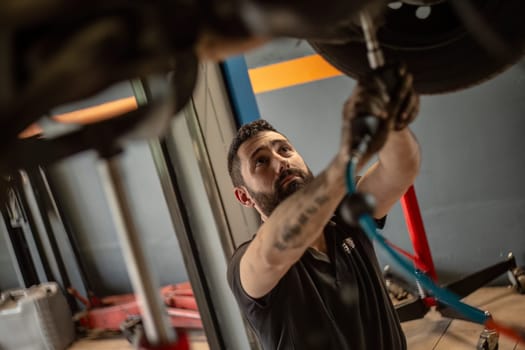 Milan, Italy 9 April 2024: Mechanic's hands delve into car engine under the hood, symbolizing repair and maintenance.