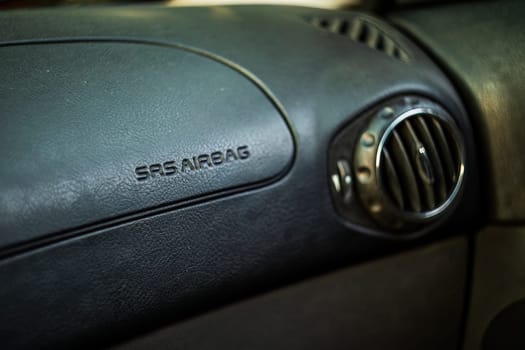 Milan, Italy 9 April 2024: Close-up of "SRS AIRBAG" warning text on a leather car dashboard.