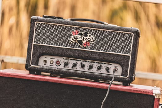 Milan, Italy 1 April 2024: A guitar amp rests atop a bold red case, ready to amplify the sounds of music. The scene exudes a vibrant and creative energy.