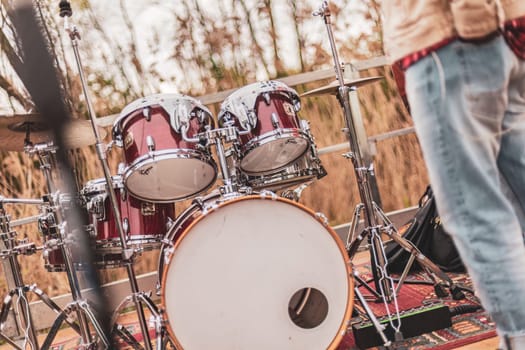 Milan, Italy 1 April 2024: A man with a strong presence stands confidently next to a vibrant set of drums, ready to unleash a symphony of beats and melodies.