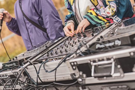 Milan, Italy 1 April 2024: Close-up of DJs' hands manipulating a console, energizing the rave party with their thrilling music set.