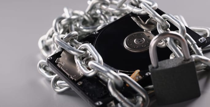 Computer hard drive is wrapped in chain. Password for hard drive concept