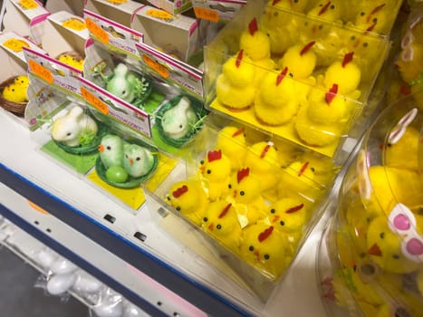 Milan, Italy 9 April 2024: Colorful decorative Easter chicks displayed on a store shelf for the holiday season.