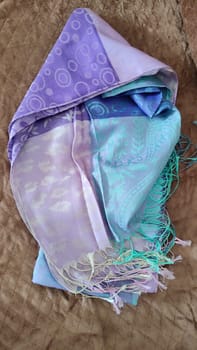 purple blue folded scarf abstraction on fabric, silk, brown bedspread. High quality photo