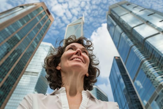 Upbeat mature woman enjoys urban life, smiles with city skyscrapers rising in background under a blue sky with clouds. Generative AI