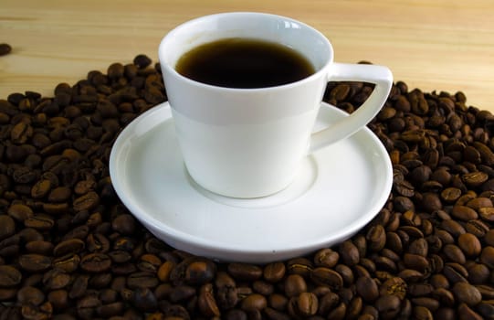 Coffee in a cup. A cup of coffee with a saucer on the background of coffee beans.