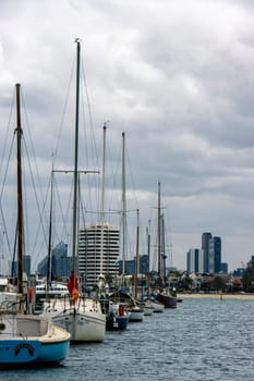 Line of sailboats with background of Melbourne city taken at the famous St Kilda. Moody photograph on an overcast day.