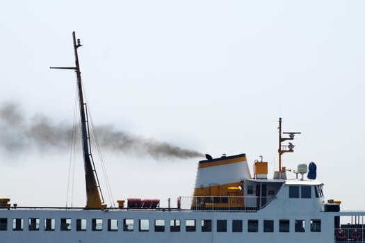 Black smoke from the chimney of a passenger ferry close up