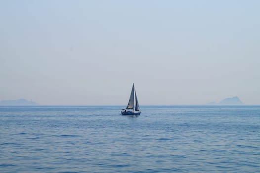 small sailing yacht at sea against the background of the sea horizon.
