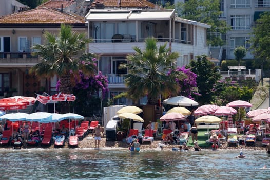 view of the beach with vacationing tourists on Buyukada island, Turkey
