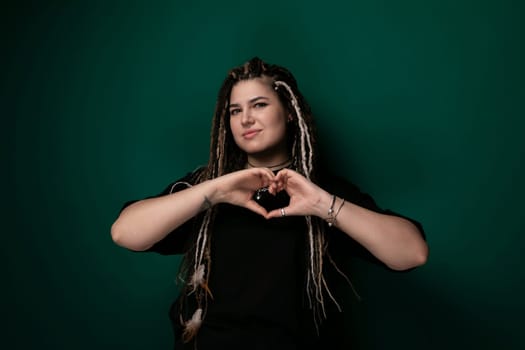 A woman is forming a heart shape with her hands, symbolizing love and affection. Her fingers are curved to create the recognizable heart outline, emphasizing a gesture of care and adoration.