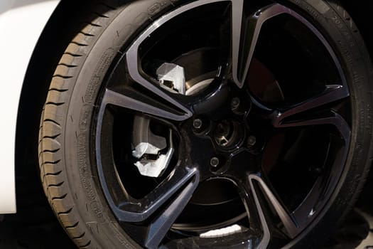 Up-close view of a shiny white car tire with intricate tread patterns.