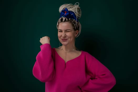 A woman is depicted wearing a pink sweater and a blue bow in her hair, standing in a neutral background.