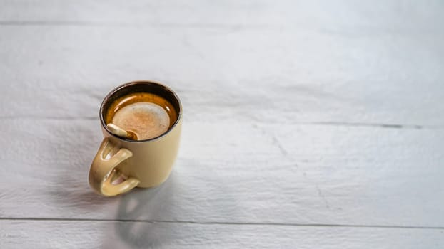 Cup of coffee on a white wooden table. Breakfast concept, top view and copy space