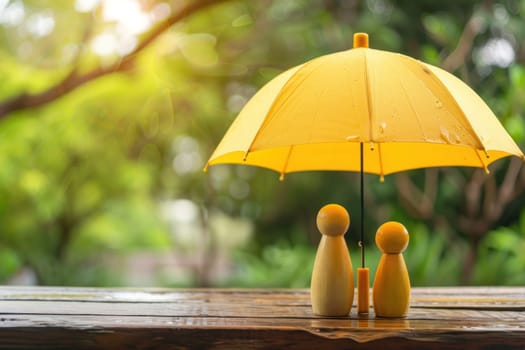 Two people are standing under a yellow umbrella.