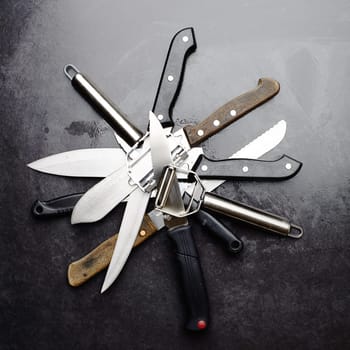 Kitchen, knives and tools with peeler on table in restaurant for cooking with professional set. Steel, service and metal slicer utensils on counter in cafe or culinary equipment for meal prep.