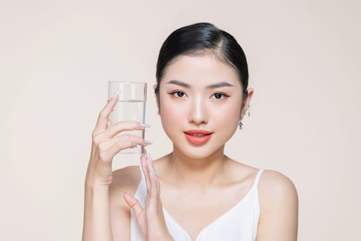 Woman with glass of fresh water in white portrait.