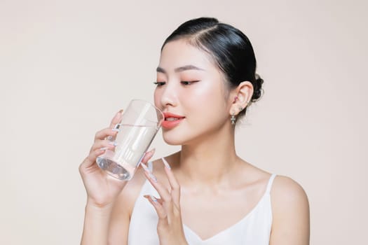beautiful girl drinking water from transparent glass isolated on white