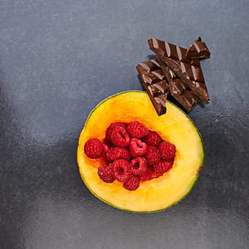 Fruit, healthy raspberries or chocolate in restaurant for balanced diet, nutrition or natural vitamin A. Vegan, top view or organic cantalope on kitchen countert for meal or snack on gray background.