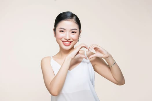 Portrait of young beautiful asian woman hands gesture in heart shape 