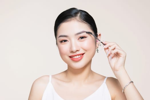 Girl makes makeup. Beautiful woman apply mascara on eyelashes with cosmetic brush
