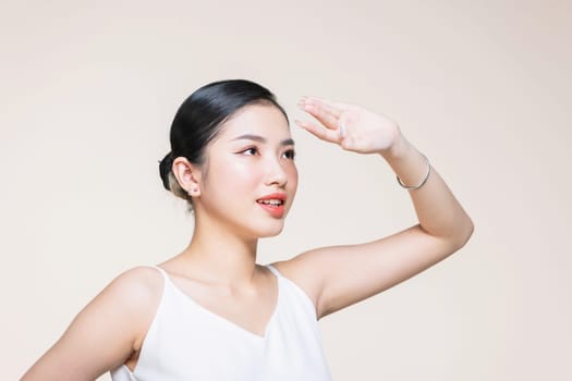Beautiful asian woman with healthy perfect face skin covering face with palm from sun.