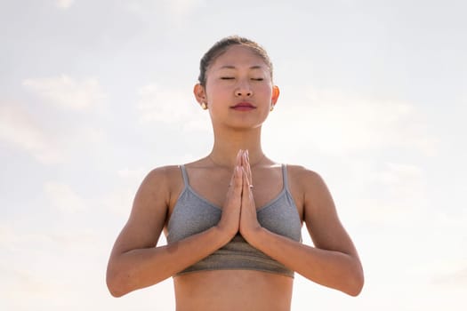 portrait of young asian woman practicing yoga in pray position, concept of mental relaxation and healthy lifestyle, copy space for text