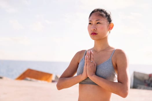 portrait of young asian woman practicing yoga in pray position, concept of mental relaxation and healthy lifestyle, copy space for text