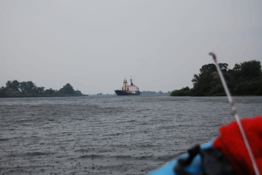 Ship on the Dnieper River, Ukraine.Gray rainy day. The ship is sailing along the fairway of the Dnieper River.