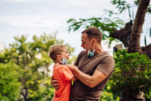 Father and little son hugging, making faces, show a tongue, open mouth, funny plays. Happy childhood.