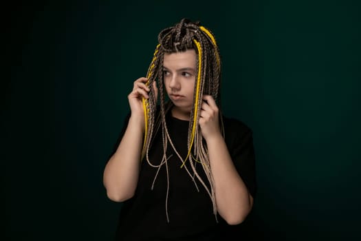 A woman with dreadlocks is seen holding her hair in front of her face. Her hands are gently gripping the tangled strands as they cascade down. The focus is on the intricate textures of her hair against her skin.