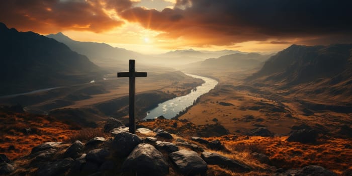 A cross perched atop a hill overlooking a river in a scenic landscape.