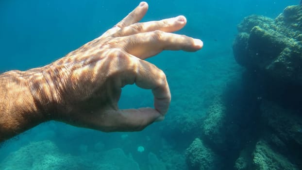 ok sign human hand underwater detail close up
