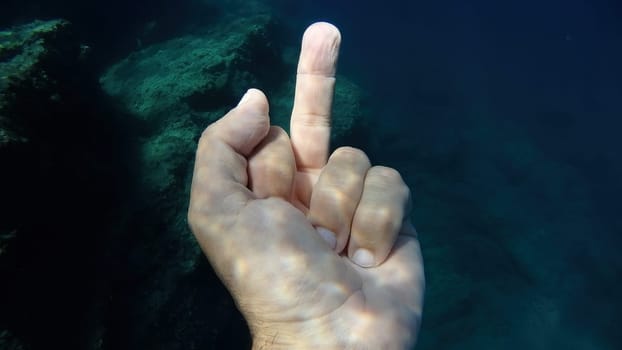 medium finger raised up human hand underwater detail close up