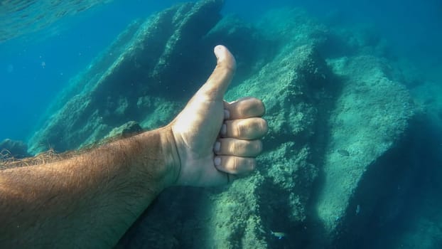 thumb up ok human hand underwater detail close up