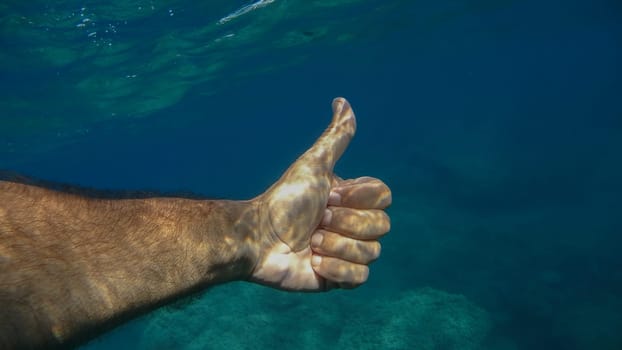 thumb up ok human hand underwater detail close up