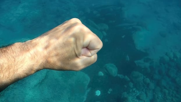 fist close palm human hand underwater detail close up