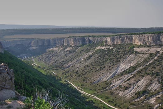 The canyon goes into the distance and at its end there is a village.