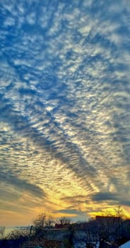 The sun illuminates the elongated clouds in yellow.