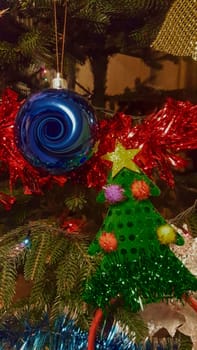 There are garlands and toys on the tree, a beautiful blue spiral-shaped ball.