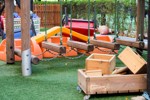 Empty playground with various equipment and toys on green synthetic grass